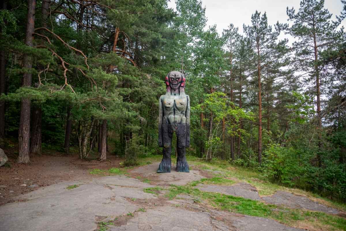 Wooden troll statue standing among trees in Ekebergparken.