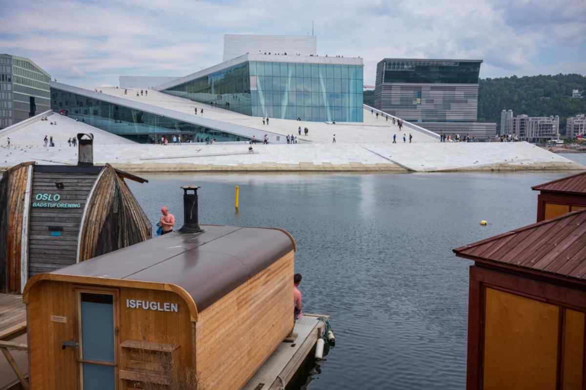 Floating wooden saunas in front of the Oslo Opera House on the harbor.