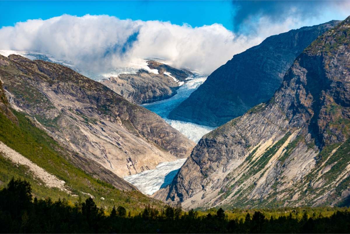 Blue glacier in Norway Blue glacier tongue flowing down between steep grey mountainsides