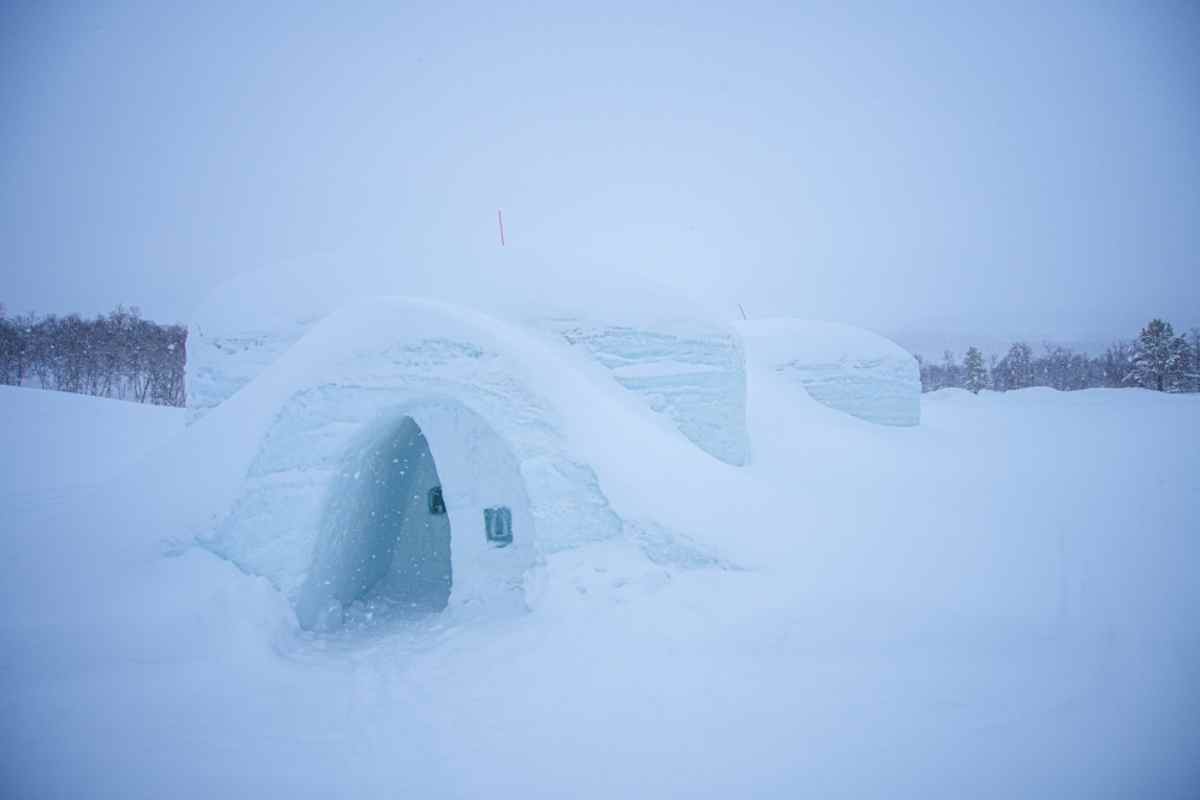Snow-covered igloo structure in the Arctic wilderness.