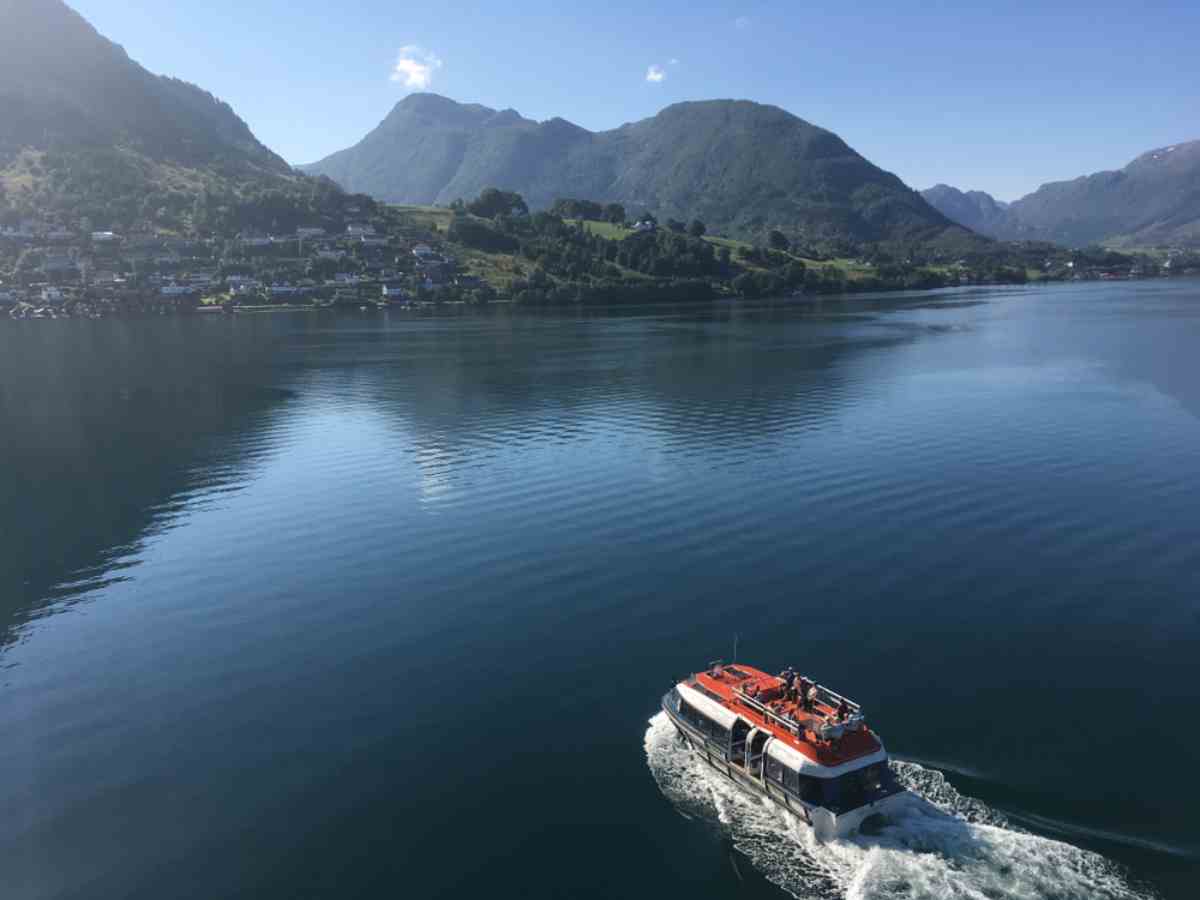 Small ferry cruising through a fjord near Bergen, Norway.
