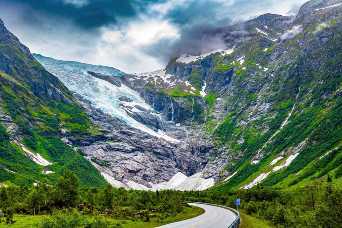 Norway's Jostedalsbreen Mountain road leading toward Nigardsbreen glacier with dramatic clouds and green valley scenery