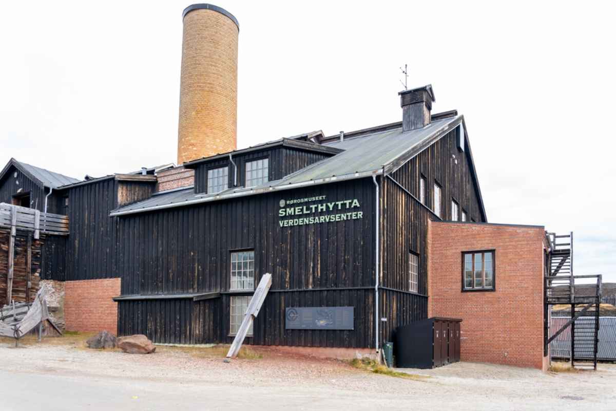 Roro's Smelthytta Smelthytta World Heritage Center building in Røros, a dark wooden structure with a tall brick chimney.