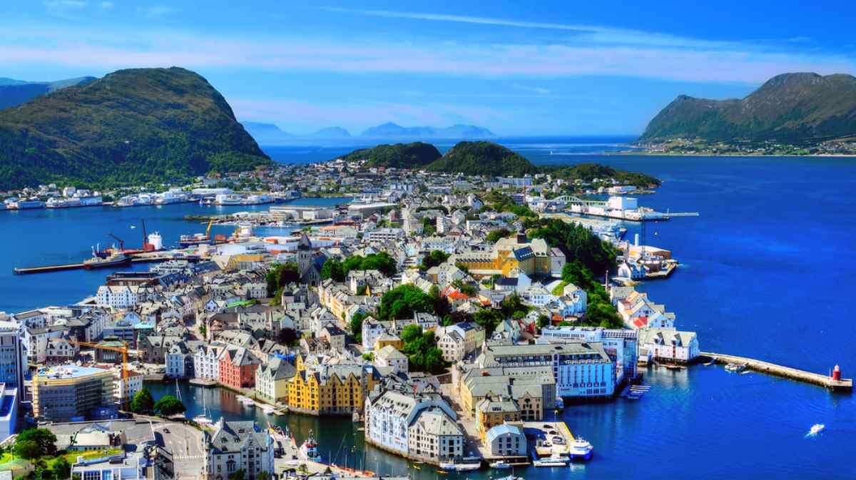 Detailed view of colorful houses in Hammerfest during winter, near what appears to be a snow-covered mountain.